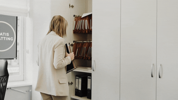 Vrouw die iets uit een kast haalt